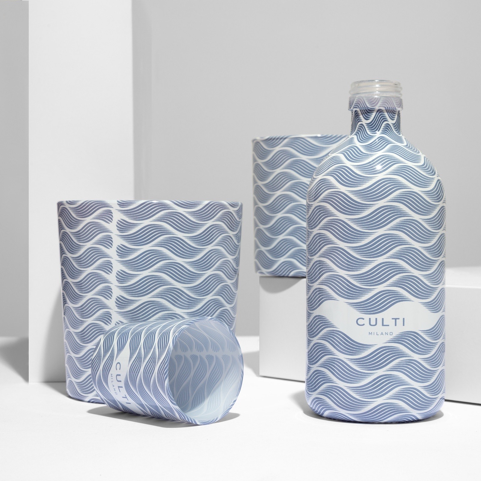 CULTI Milano Onda collection — white and blue wave pattern sublimated across diffuser bottle and candle vessels